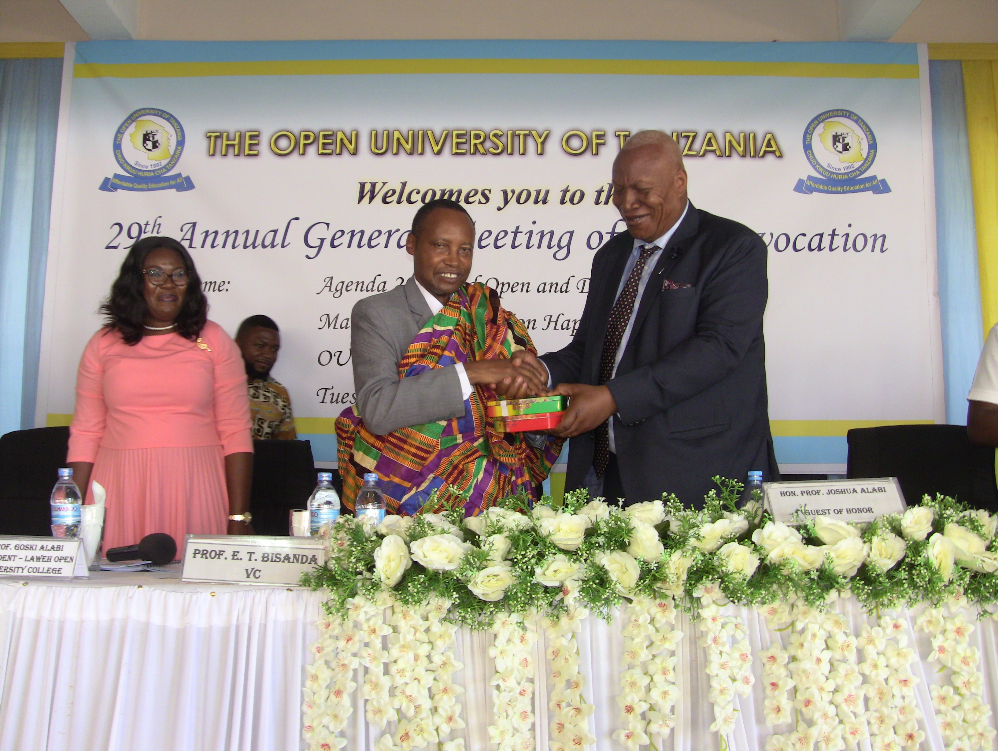 The Vice Chancellor of the Open University of Tanzania Prof. Elifas Bisanda, receives a gift from the President of Laweh Open University of Accra, Ghana Prof. Joshua Alabi during the 29th Annual General Meeting Of the Convocation