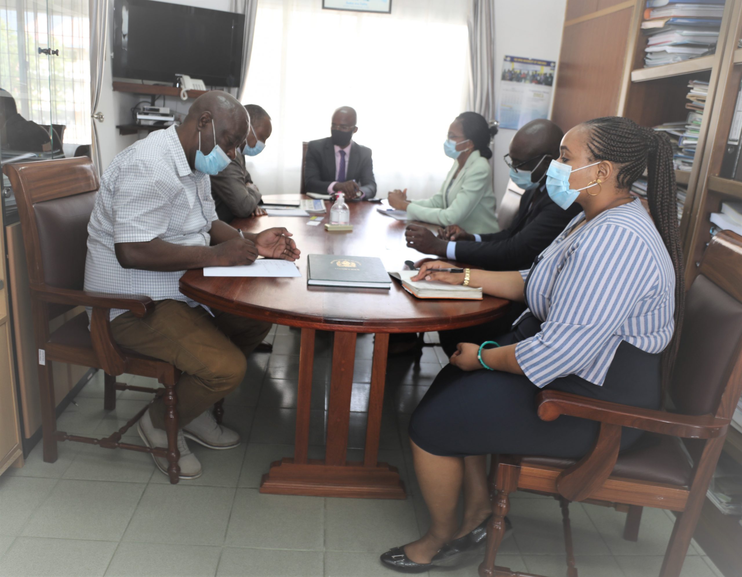 The Vice Chancellor of the Open University of Tanzania (OUT), Prof. Elifas Bisanda, embraces members of the NMB Bank PLC